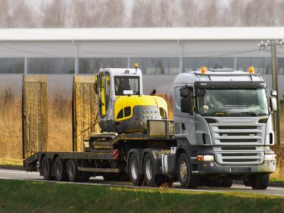 Industrial Excavator and Flatbed Truck Ready for Earthworks Industrial Excavator and Flatbed Truck Ready for Earthworks